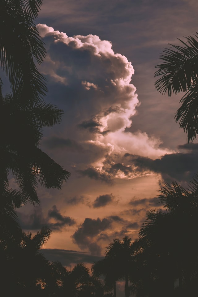 tropical destination with fluffy clouds and sunset